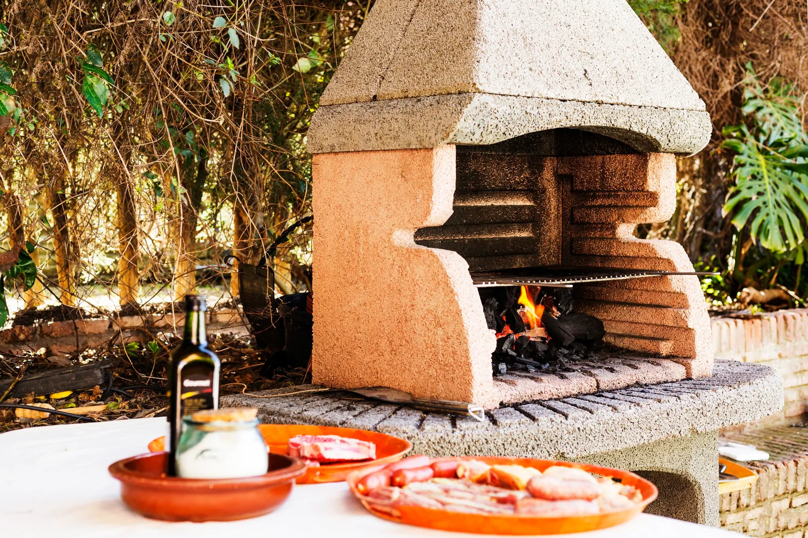 Custom stone outdoor fireplace on a covered patio in Aubrey, TX with warm evening lighting